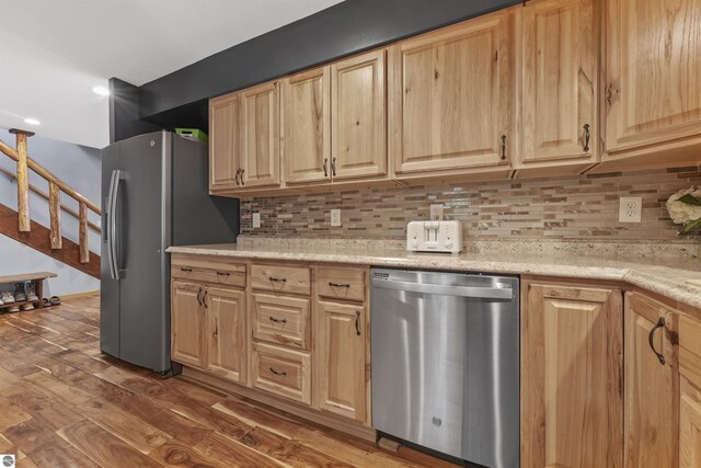 7504 W Dakota Trl, Lake City, MI 49663 - kitchen with tasteful backsplash, appliances with stainless steel finishes, light brown cabinetry, and dark wood-style floors