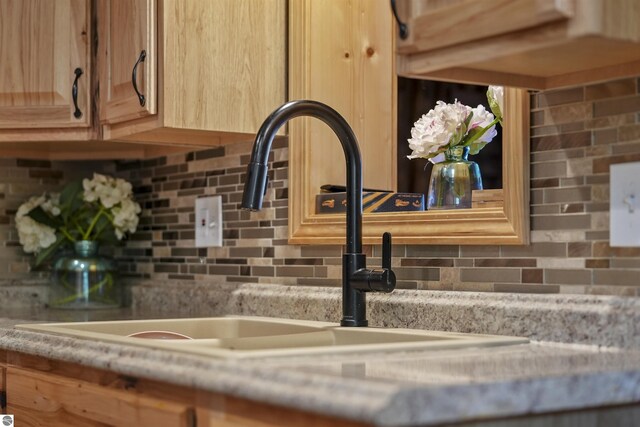 7504 W Dakota Trl, Lake City, MI 49663 - details with a sink, light brown cabinetry, and decorative backsplash