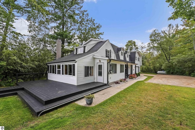 7504 W Dakota Trl, Lake City, MI 49663 - view of side of home with a sunroom, a yard, a deck, and a chimney