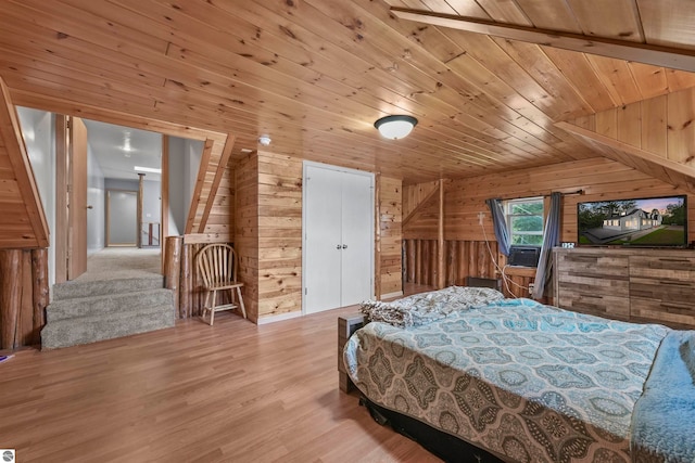 bedroom with wood ceiling, wooden walls, and light hardwood / wood-style flooring