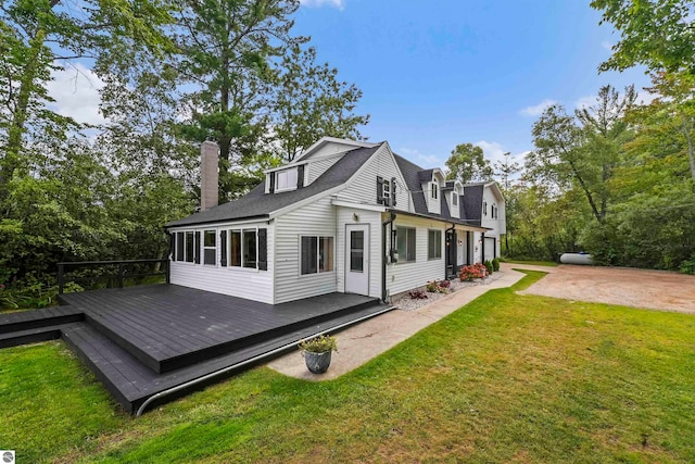 rear view of property with a yard and a deck