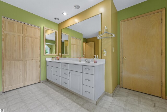 7504 W Dakota Trl, Lake City, MI 49663 - full bathroom featuring tile patterned floors, double vanity, baseboards, and a sink