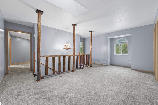7504 W Dakota Trl, Lake City, MI 49663 - empty room featuring carpet, a notable chandelier, baseboards, and visible vents