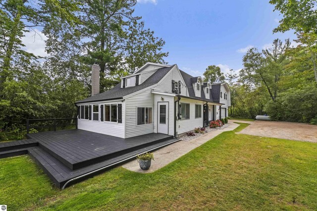 7504 W Dakota Trl, Lake City, MI 49663 - view of side of home featuring a sunroom, a chimney, a deck, and a lawn
