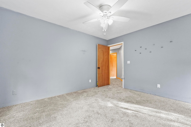 spare room featuring ceiling fan and light colored carpet