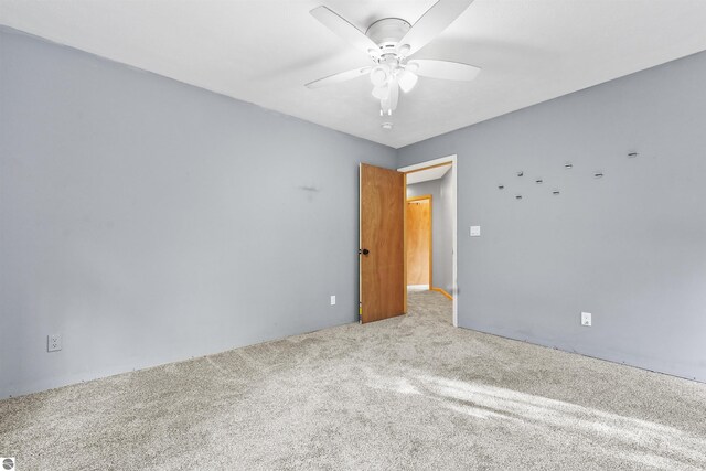 7504 W Dakota Trl, Lake City, MI 49663 - empty room with carpet flooring and ceiling fan