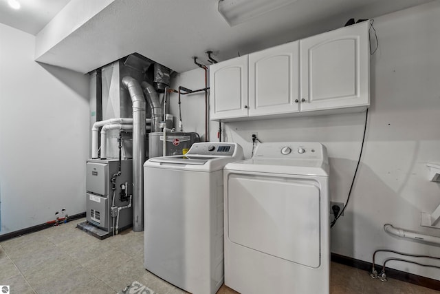 washroom with water heater, separate washer and dryer, and cabinets