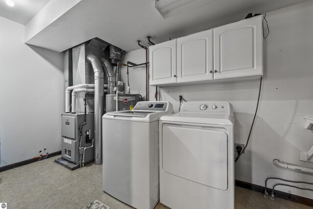 7504 W Dakota Trl, Lake City, MI 49663 - washroom featuring independent washer and dryer, baseboards, cabinet space, and water heater