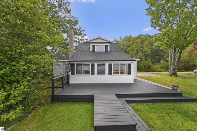 7504 W Dakota Trl, Lake City, MI 49663 - rear view of property with a chimney, a shingled roof, a wooden deck, and a lawn