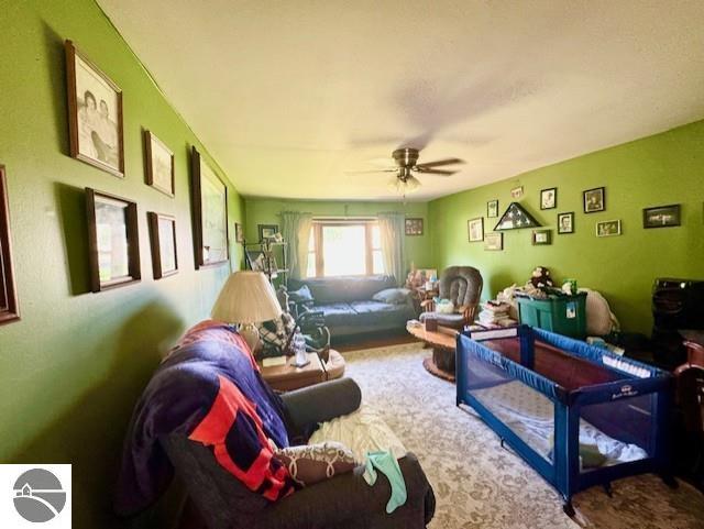 living area with ceiling fan and carpet flooring