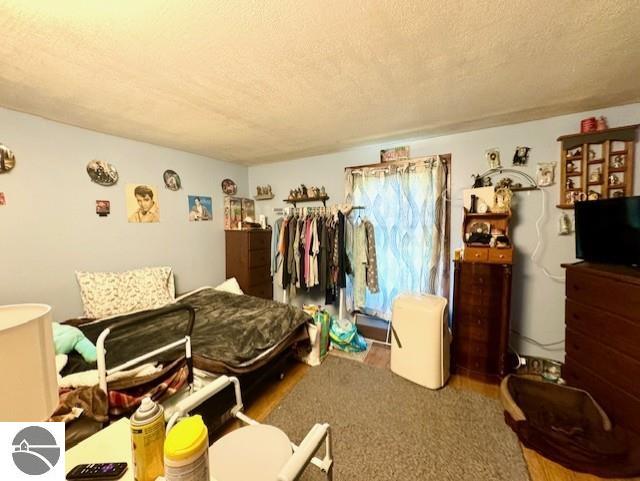 bedroom featuring a textured ceiling and wood finished floors