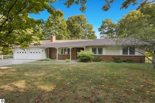 ranch-style house with concrete driveway, a chimney, an attached garage, a front lawn, and brick siding