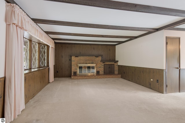 unfurnished living room featuring light carpet, wood walls, and beam ceiling