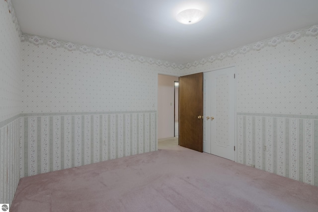 carpeted spare room with wallpapered walls