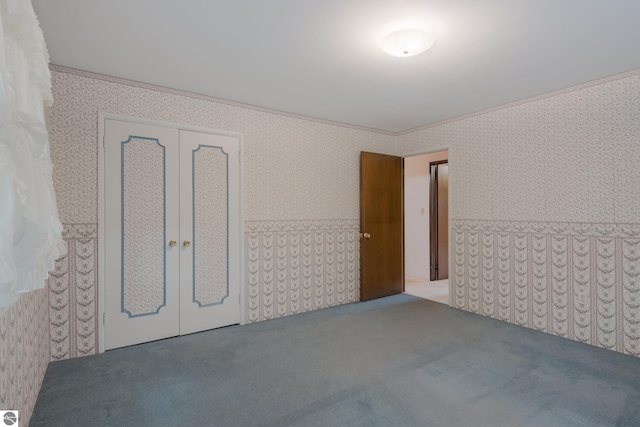 carpeted empty room featuring french doors, crown molding, and wallpapered walls