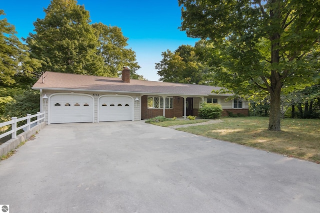 ranch-style home with a garage, a chimney, aphalt driveway, fence, and a front yard