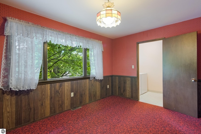 unfurnished room featuring wooden walls