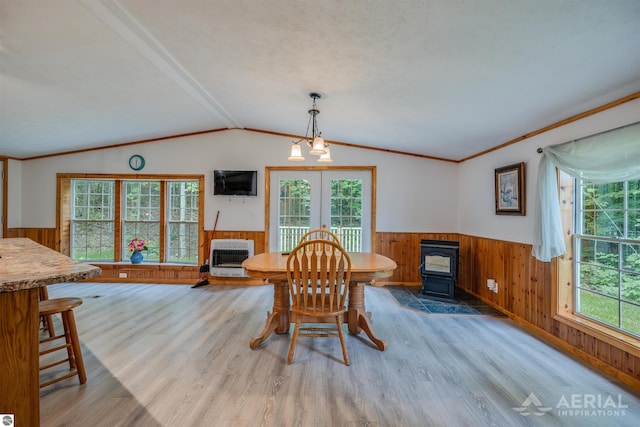 4949 N M-33, Rose City, MI 48654 - dining area with heating unit, a wainscoted wall, a wood stove, and lofted ceiling