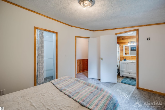 4949 N M-33, Rose City, MI 48654 - carpeted bedroom featuring wood walls, a textured ceiling, crown molding, and connected bathroom
