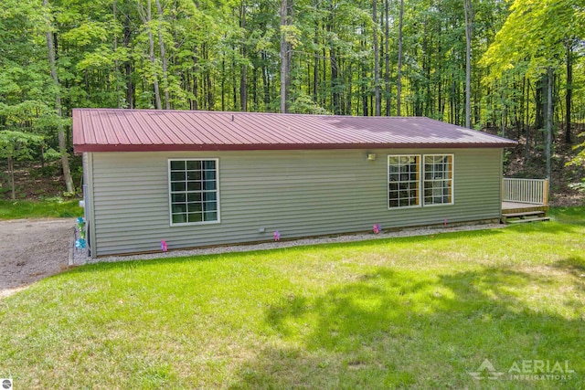 4949 N M-33, Rose City, MI 48654 - view of front of home featuring a front lawn, a wooded view, and metal roof