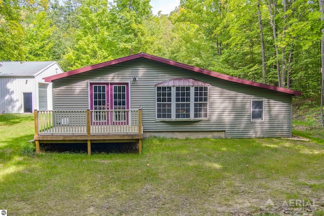 rear view of house with a lawn and a deck