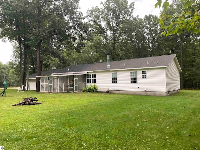 back of property featuring a lawn and a sunroom