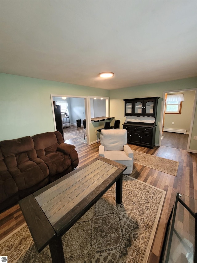 living room featuring a baseboard heating unit and dark hardwood / wood-style floors