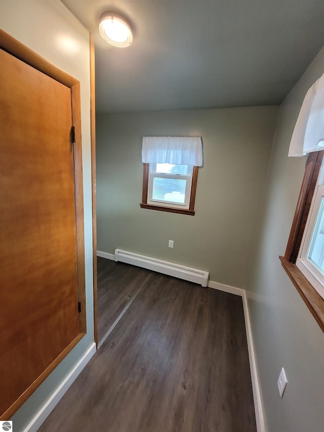 interior space with dark wood-type flooring and baseboard heating