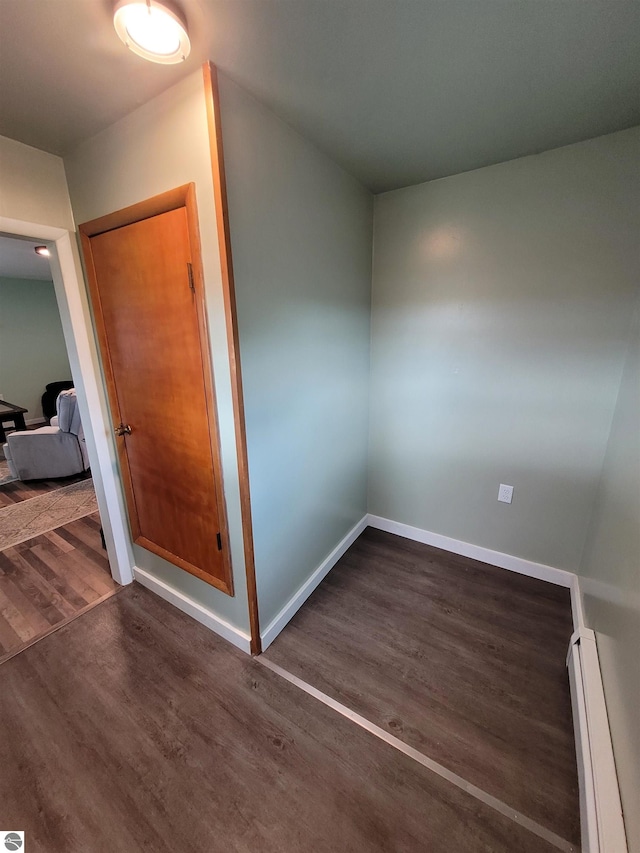 interior space with a baseboard radiator and dark hardwood / wood-style floors