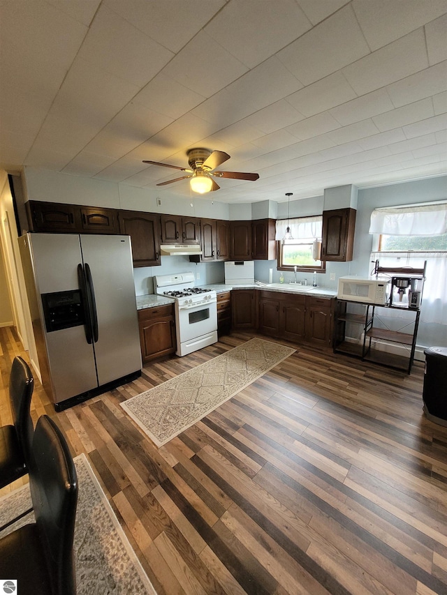 kitchen featuring dark hardwood / wood-style floors, decorative light fixtures, white appliances, sink, and ceiling fan