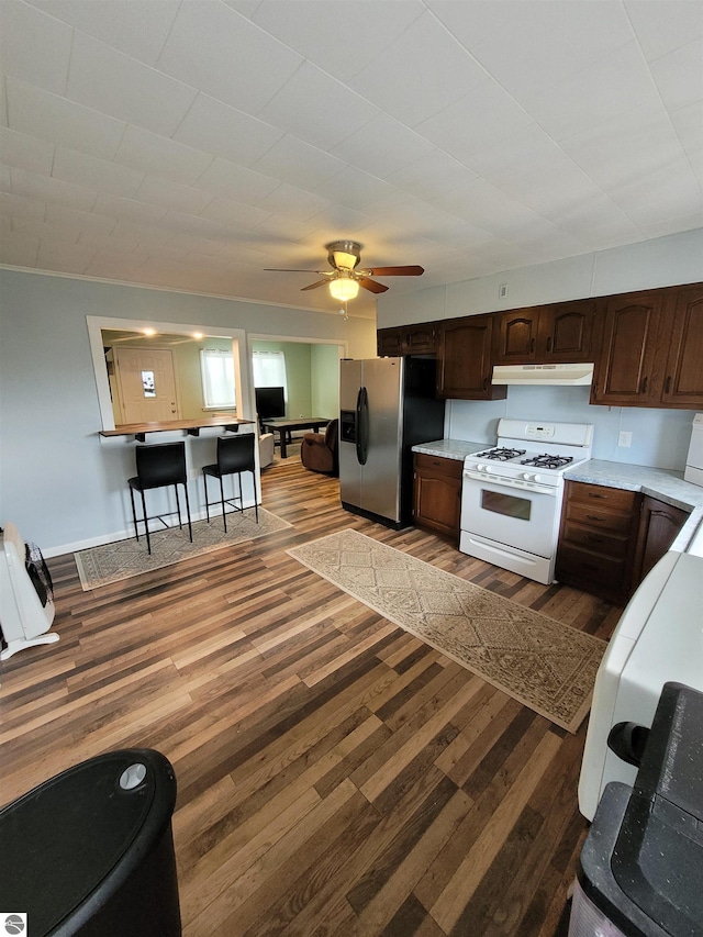 kitchen with white range with gas cooktop, dark brown cabinets, dark hardwood / wood-style flooring, stainless steel fridge with ice dispenser, and ceiling fan