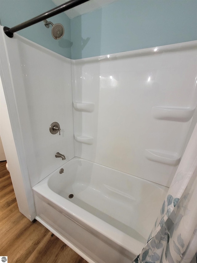 bathroom with shower / bath combo with shower curtain and wood-type flooring