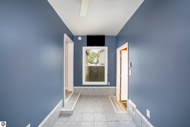 hall featuring light tile patterned flooring