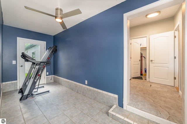 workout room featuring baseboards, a ceiling fan, and tile patterned floors