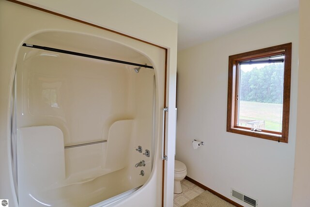 full bathroom with visible vents, baseboards, toilet, shower / bath combination, and tile patterned floors