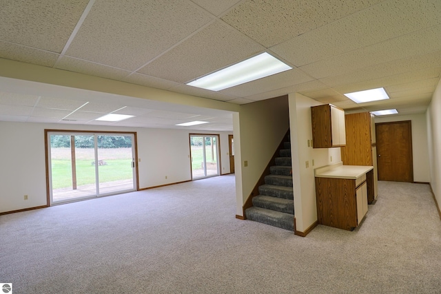 basement with light colored carpet and a drop ceiling