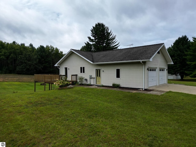 rear view of house featuring a yard and a garage