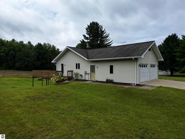 view of front facade with a front yard, a detached garage, roof with shingles, and a wooden deck