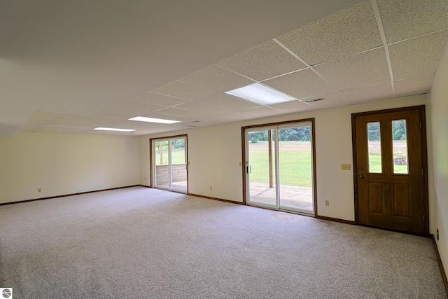 spare room with light colored carpet and a drop ceiling