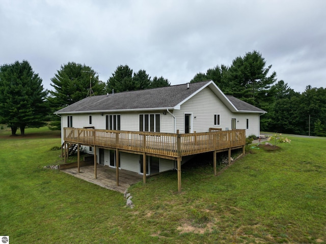 back of house featuring a wooden deck and a yard