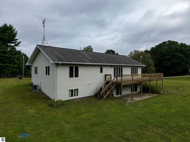 rear view of house with a wooden deck, a yard, and central air condition unit