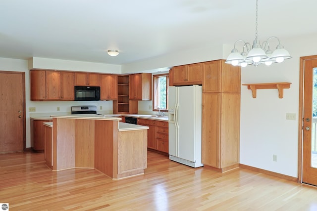 kitchen featuring light wood-type flooring, black appliances, a notable chandelier, and sink