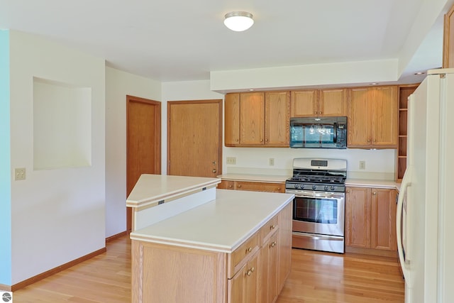 kitchen featuring white refrigerator, light hardwood / wood-style flooring, a center island, and gas stove