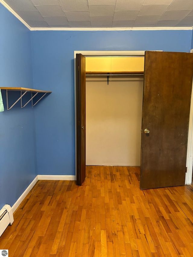 interior space with hardwood / wood-style flooring and a baseboard heating unit