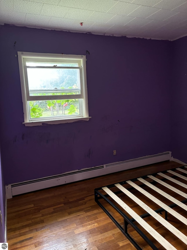 empty room featuring dark hardwood / wood-style floors and baseboard heating