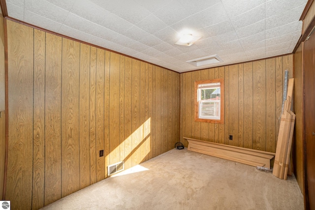 carpeted spare room with wood walls