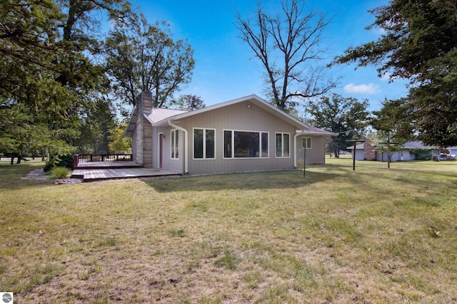 rear view of house with a wooden deck and a yard