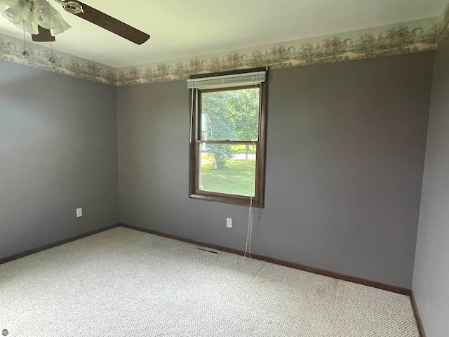 carpeted spare room with ceiling fan