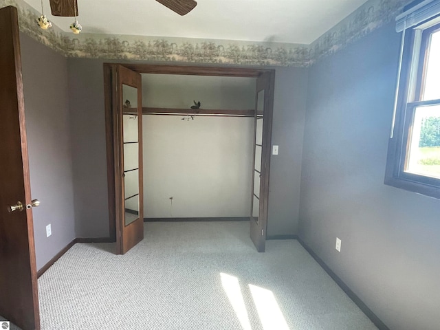 unfurnished bedroom featuring light carpet and a closet