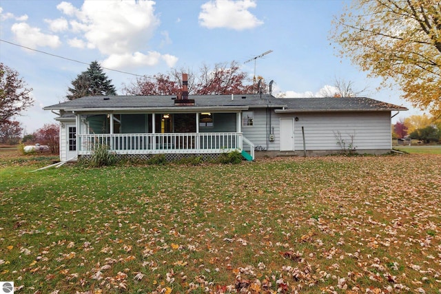 rear view of property featuring a lawn